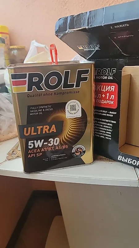 Жестяная банка Rolf Ultra 5W-30 рядом с коробкой акции 4 л + 1 л в подарок, на этикетке ACEA A7/B7, A5/B5 и API SP