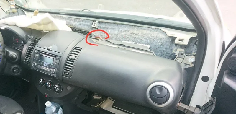 Торпеда Nissan Note со снятой верхней накладкой, красным обведены провода вентилятора печки под ней