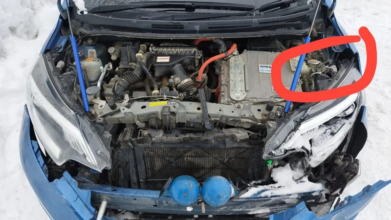 Ноут e-Power после аварии с открытым капотом, красным обведен угол за разбитой фарой