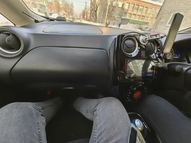Колени пассажира под бардачком праворульного Ноута e-Power, снято с пассажирского места